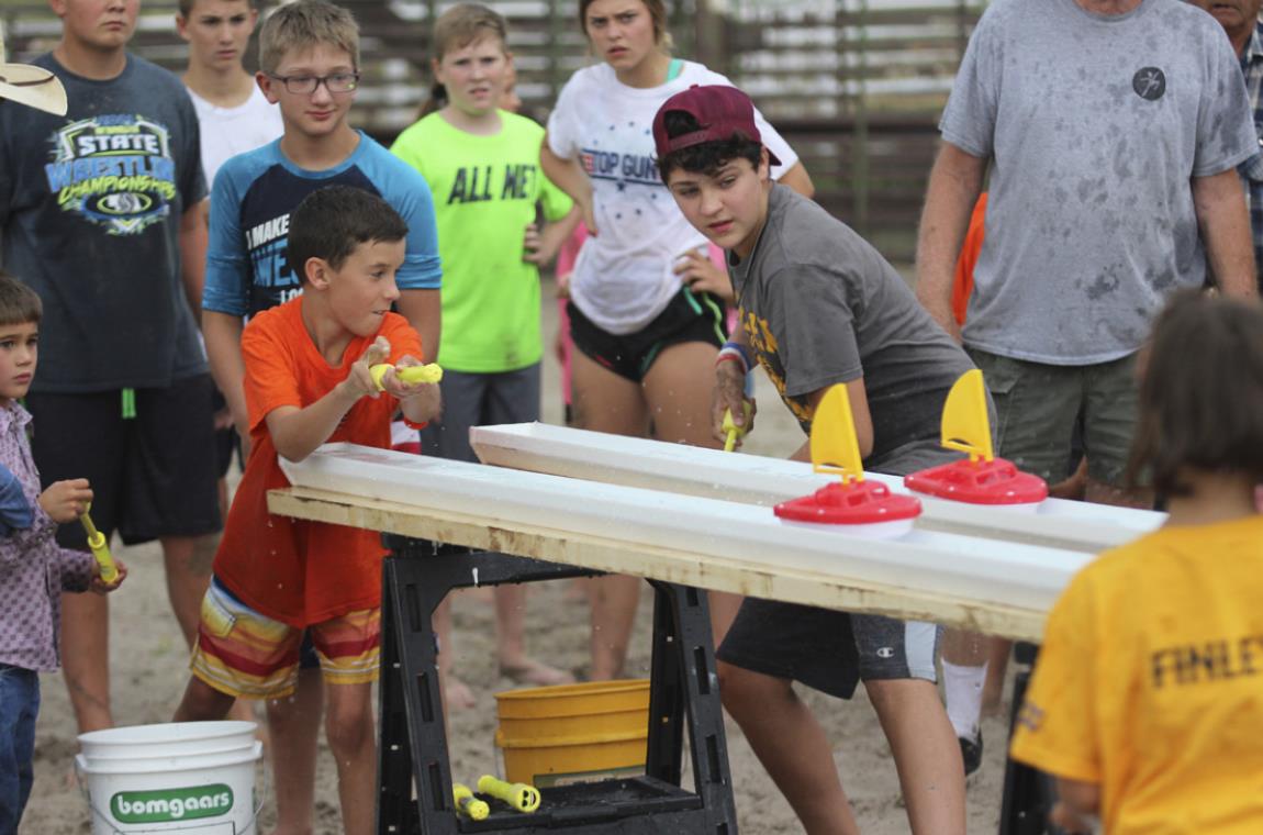 Brandt Mundorf (left) and Jaylon Forsen compete in the Rain Gutter Boat Race during the Redneck Hunger Games. Gerri Peterson