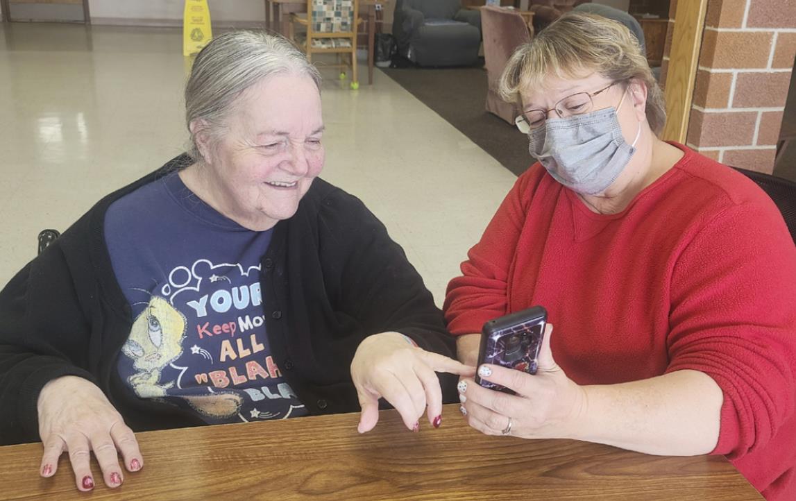 Ann Connell enjoying pictures of Vicky Earl’s grandson.