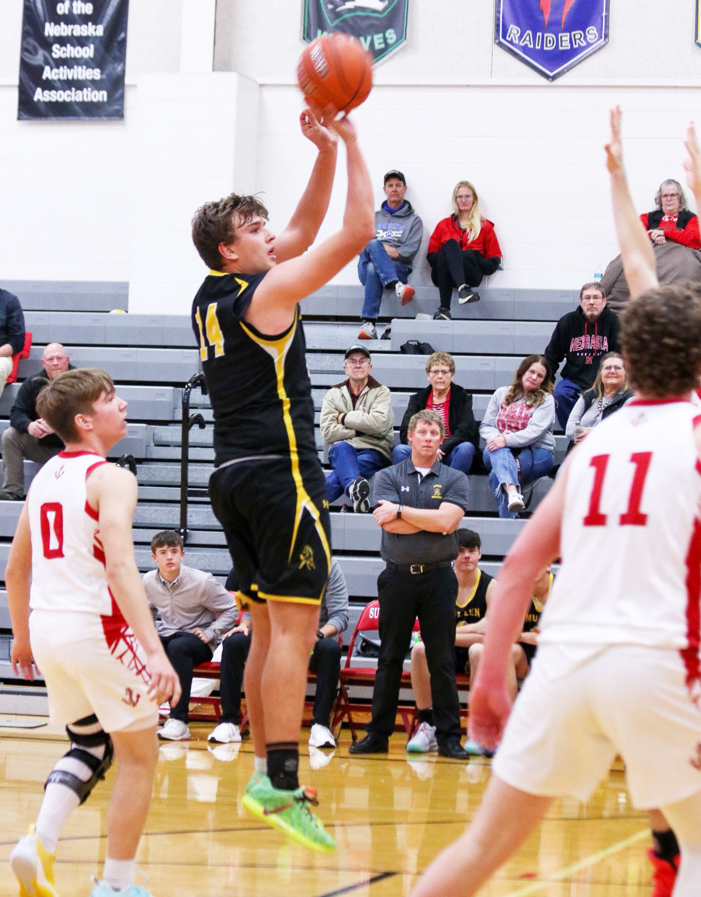 Jacob Walker puts up a shot at Sutherland, while Head Coach Brad Wright looks on from the bench. Carolee Brown Photography