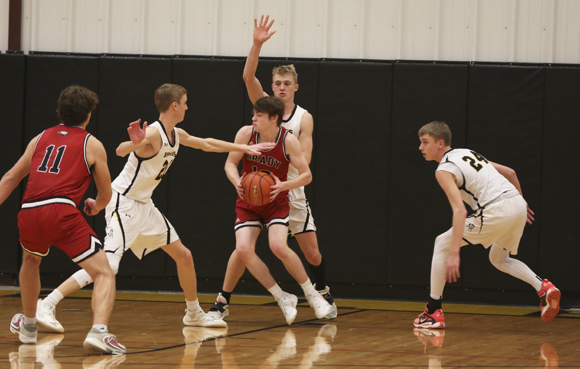 A Brady player is surrounded by Moores - brothers Alex and Kaleb Moore on the left and right, and their cousin Clayton behind him. Megan Andersen