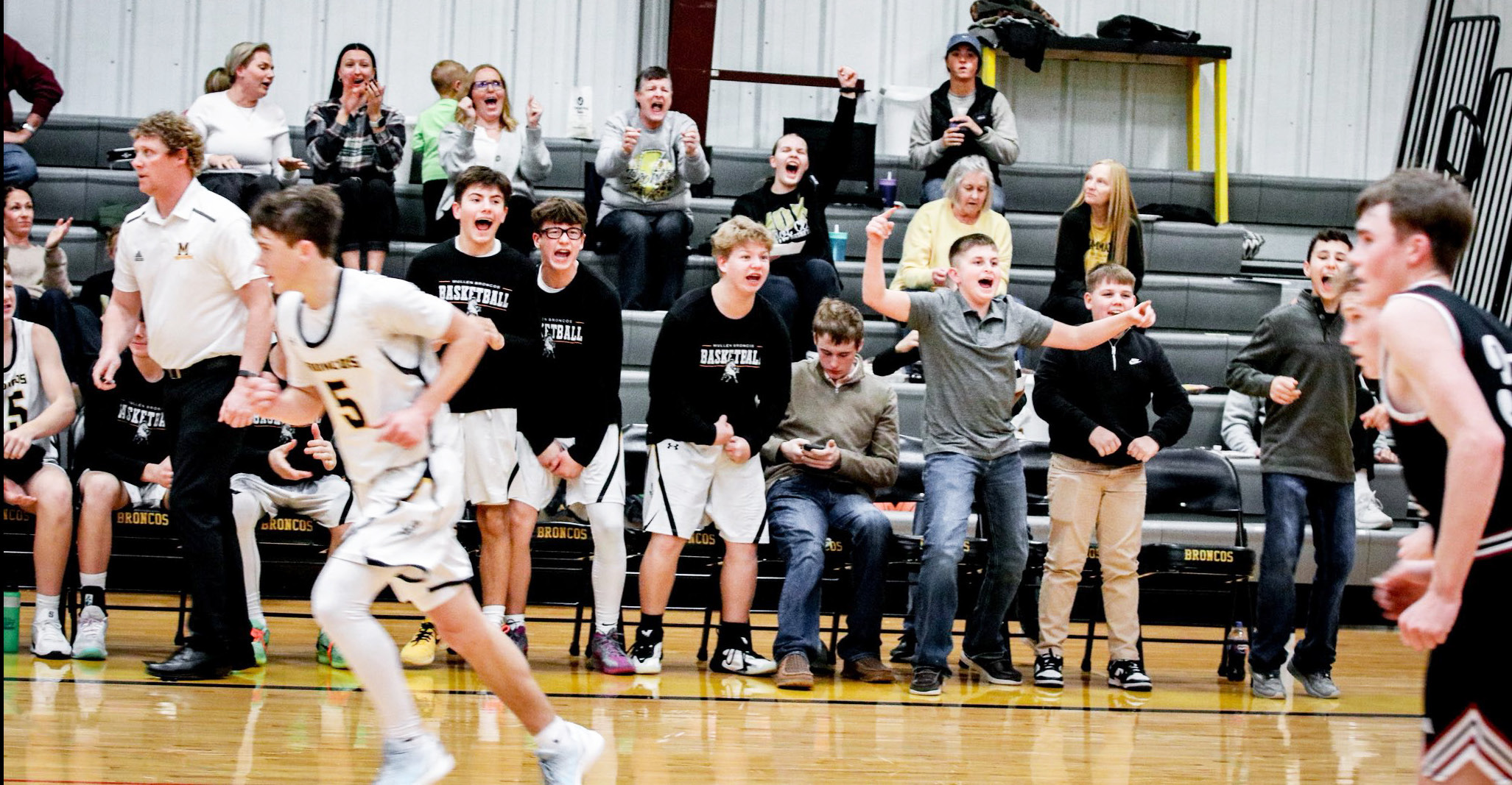 The crowd and bench cheer during the Broncos’ third quarter run against Twin Loup last Tuesday. Carolee Brown Photography