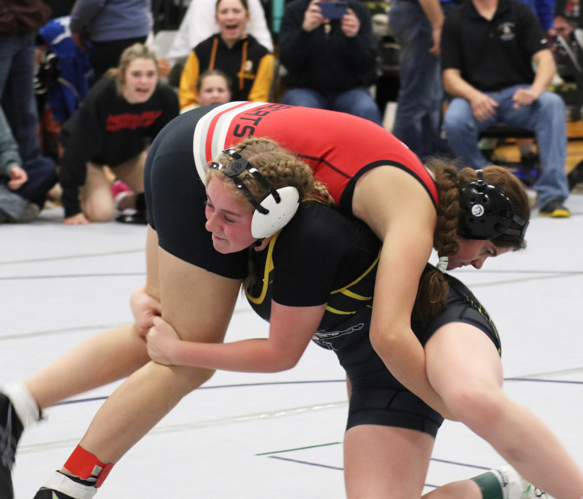 Kassidy Cheever competing in Oshkosh with her teammates cheering her on in the background. Joni Cheever