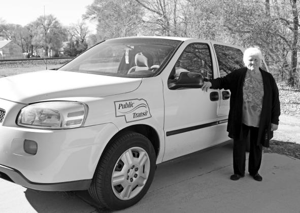In this photo from 2015, Darlene Osborn stands next to one of the vans she drives for Hooker County Transit. Osborn is still a driver, along with Artis Hicks. file photo