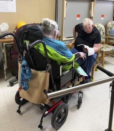 Steve Springer reading to his wife Twila Springer on a visit.