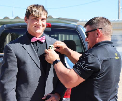 MPS Superintendent Chris Kuncl pins Homecoming royalty candidate Tate Kvanvig’s boutonniere on last Friday during the Pep Rally.