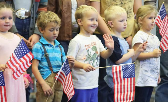 Preschooler Arthur Polt waves to his family in the audience last Tuesday at the Veterans Day program. Also pictured, l-r: Libby Kraye, Burke Mundorf, Arthur, Mason Deibler and Kyla Crisp.