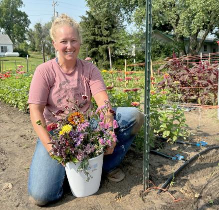Justa Deibler with a bucket full of her flowers she snipped at the lot last Thursday morning. Gerri Peterson