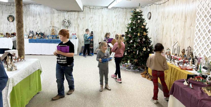 With clipboards in hand, elementary students search for specific items amongst the nativities last week. Roxann Brown