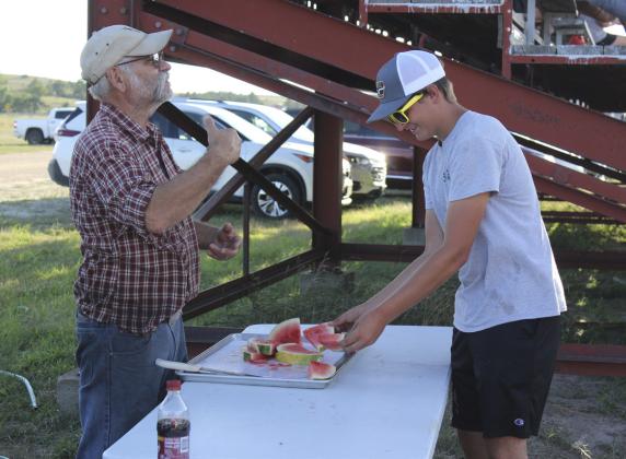 A secret business owner “Fair Santa” donated all of the watermelon that was enjoyed by everyone at the fair events. Chuckwagon ‘n Jug’s Gregg and Dawn Mallory helped serve them. Here Gregg tells fair-goers at the Redneck Hunger Games that they have two hands, therefore they need two pieces of watermelon! Gerri Peterson