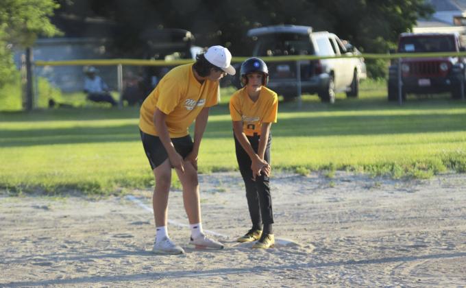 Coach Jarren Forsen with words of advice to Bo Pettit while waiting on third base during the baseball game against Thedford on Monday, June 19. Gerri Peterson