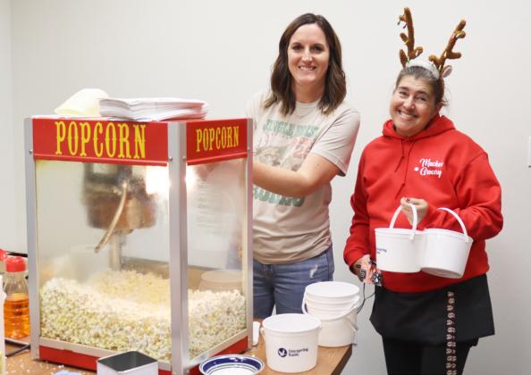 Dayspring Bank employee Traci McCully gets ready to dish up popcorn buckets for Melanie Overmyer to take back across the street to her fellow employees at Macke’s Grocery during the Walkabout.