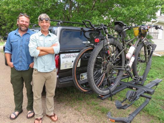 A pickup carrying water, food, other supplies and at least one support person drives with Andy Caven (left) and Mike Forsberg, pictured at Rowe Sanctuary, on their 2,500-mile bike ride from south Texas to northern Saskatchewan. Their bicycles are designed for gravel roads and 'bikepacking.' Lori Potter