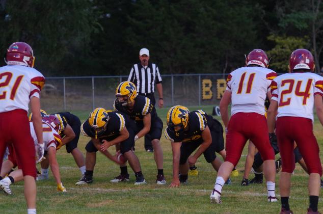 Quarterback Clayton Moore calls for the snap from center Samuel Coble during the Leyton game. Also pictured are offensive linemen Sean Simonson and Adam Wiens.