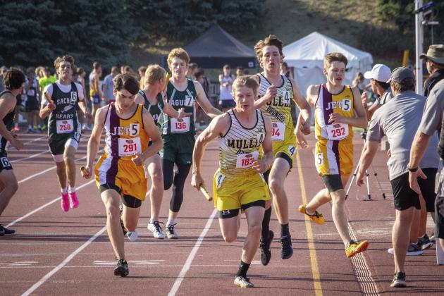 Justin French takes off for his leg of the 4x400 relay after his handoff from Chase Gracey.