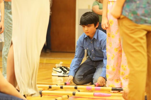 5th grader Lorenzo Gonzalez concentrates during his turn to run the sticks during the Tinikling Stick Dance last Tuesday.