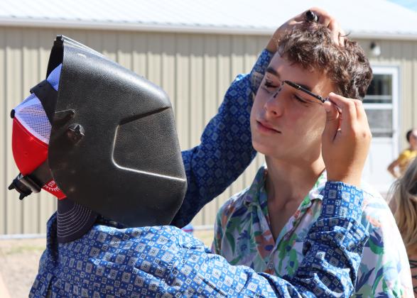 Trios from grades 6-12 competed in a makeover contest at the Homecoming Pep Rally, where there was a model, artist and director... except the artist had limited visibility, wearing a welding helmet, while the director told them what makeup to use! Above 8th grader artist Colin Connealy attempts to put mascara on Brandt Mundorf.