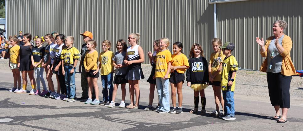 Some of the 3rd-5th grade students led the crowd in singing the school song, led by K-8 music teacher Mary Jo Walker (right).
