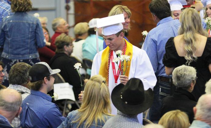 Kyle Finney hands his brother Jared a flower during graduation. Gerri Peterson