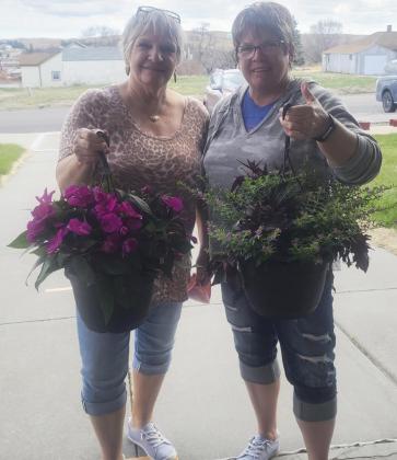 Chris Sittler (left) and Pam Coons with the flowers that they brought up for residents to enjoy.