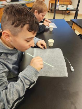 The Mullen sixth graders are studying weather. Last week in Mrs. Jewell’s class, they learned about how water droplets will interact with one another, and how that impacts our weather in the atmosphere. Pictured are Gunner Brown and Justin Kraus. Tawn Jewell