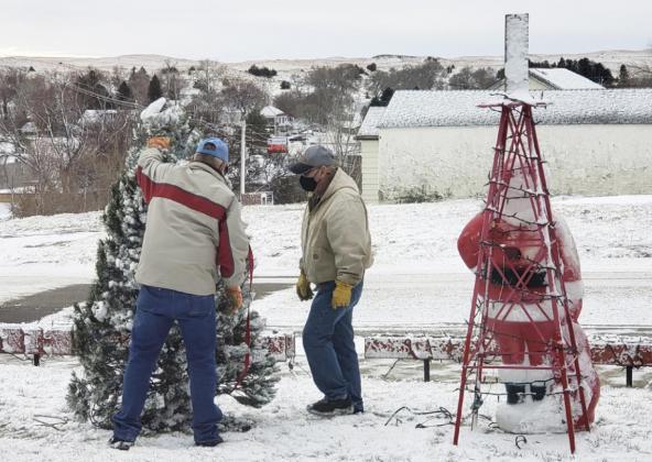 Teamwork makes the dream work. The Christmas tree and Santa did not do well with the storm last week. Willard Boyer and Darrell Leibhart get it all set back up.
