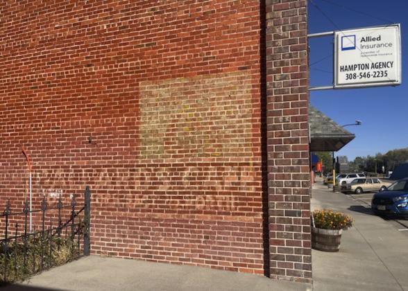 The sign on the west side of the downtown Mullen Hampton Building with directions to the Ballard Cafe is faded but still visible today.