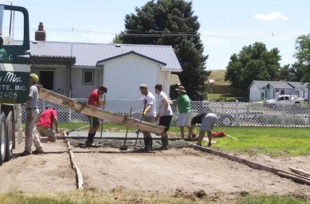 Chris Kuncl, Justin Moore, Casey Phillips and Mike, Tel and Tate Kvanvig helped pour the first round of cement for the basketball court on June 22. Arla Kvanvig