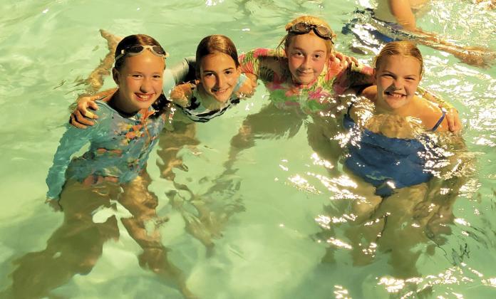 L-r: Sixth graders Taylor Moore, Abby Gracey, Kassidy Cheever and Maci Walz at the Night Swim last Friday night. Bri Moore