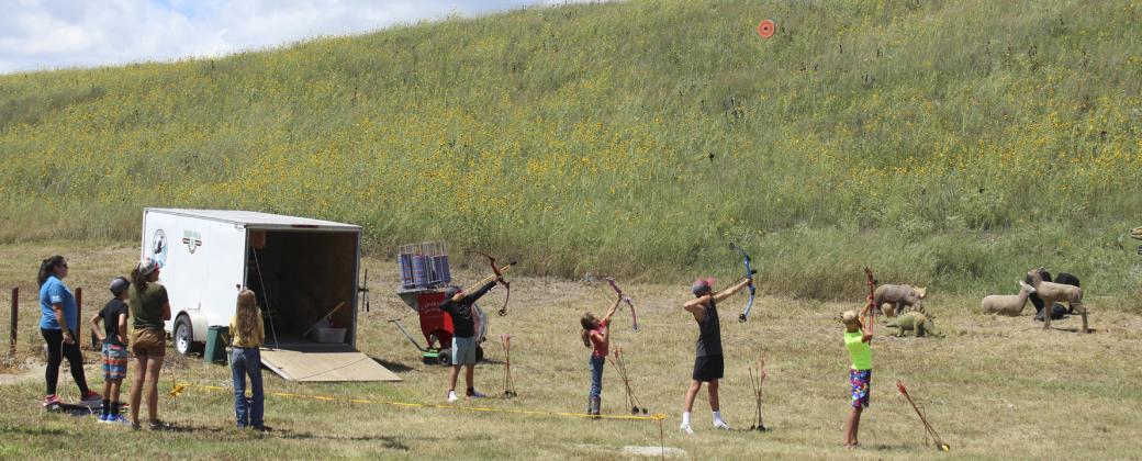 Aiming for the flying target at the 4-H archery trailer are l-r: Colin Connealy, Finley Mundorf, Cian Connealy, Teal Peterson.
