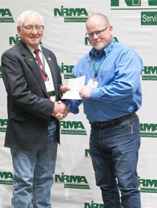NIRMA Board of Directors Member R. Buddy Small (left) presents a dividend check to Hooker County Sheriff Todd Yost. courtesy photo