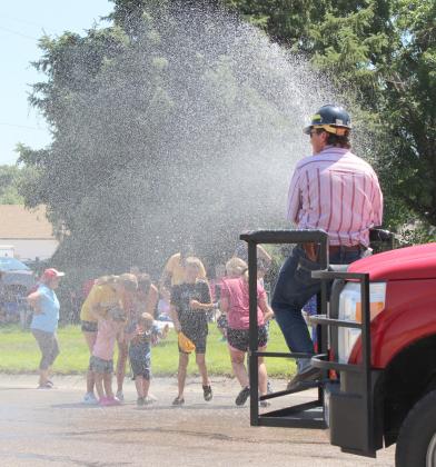 With temperatures over 100, parade watchers of all ages gladly stepped into the spray hose that Mullen Volunteer Fire Department Owen Thorberg was running!