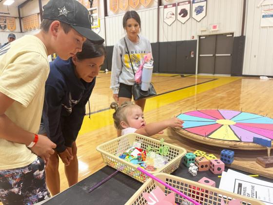 Kynlee Bloom checks out a FCCLA Carnival game while uncle Braylon Kuncl, grandma Janie Kuncl and mom Jocelyn Bloom look on.
