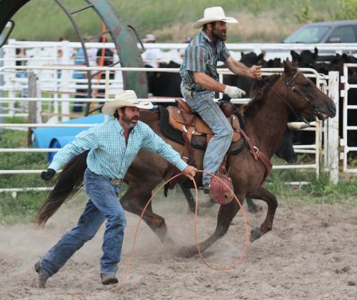 Left: Brett Phipps runs to help the rest of his teammates load the trailer, while Ty Kenner races to drop the chalk in the bucket from their branding.