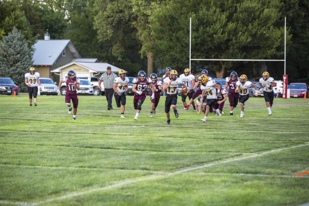 Quarterback Chase Gracey sprints down the field with his teammates and the Twin Loup team in hot pursuit. Jadyn Andersen