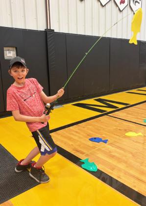 Jaxyn Evans shows off his catch at the casting pole station.