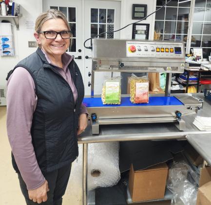 Deb Cox with the sealing machine she was able to purchase with part of her Mullen Commercial Club business grant. courtesy photo