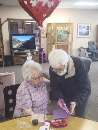 Nadene Andersen with Karol Young looking at a Valentine’s card made from their youth group!