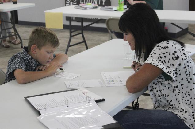 Cooper Phillips discusses his electricity project, a homemade flashlight, during 4-H interview judging last Thursday. Gerri Peterson