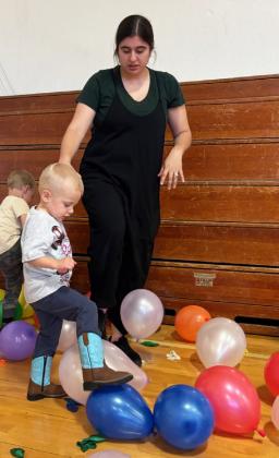 The FCCLA Carnival was held last Thursday, April 10 at the Lariat. Games for all ages were available. Pictured above is FCCLA member Jack Coble watching Violet Stichka try her hand at spinning the wheel to win tickets. Right: William Spurlin tries his hand... or foot at the balloon pop with mom Morgan Spurlin. Gerri Peterson
