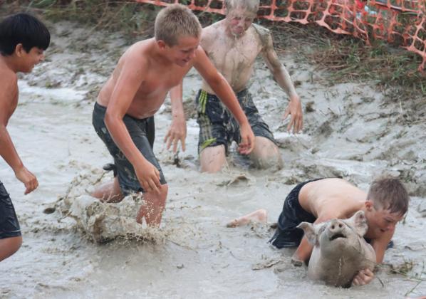 Gus Wingebach holds onto his team’s pig while the rest of his teammates head his way - Lorenzo Gonzalez, Caleb Deibler and Jedd Kraus - who had dove for the pig already! Gerri Peterson