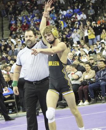 Eli Paxton wins the gold medal at 120, while part of the Mullen crowd can be seen in the background celebrating with him. Kris Forsen