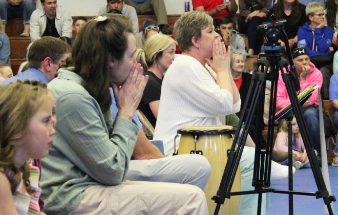 Mullen music teacher Mary Jo Walker (right) and para Laurie Monette help the kindergartners with their song actions.