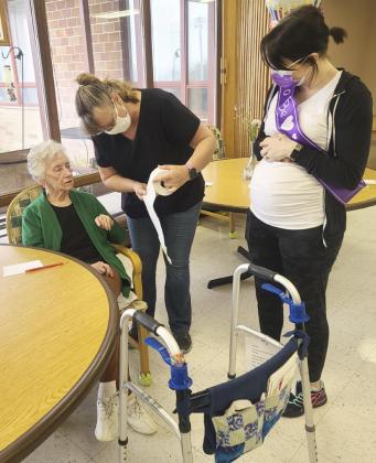 How big is Kate’s baby belly? Patsy Wadas helps Wanda Mackley guess how many squares of toilet paper it will take to go around Kate Dailey’s belly.