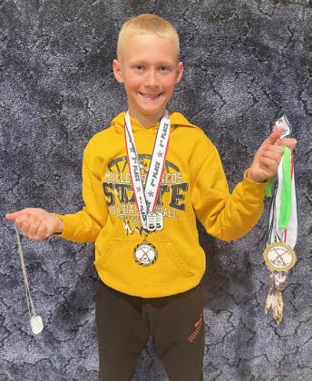 Teal Peterson wearing his medals and holding the rest of Mullen’s medals at Rushville.