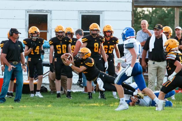Quarterback Bo Pettit, Jr., reaches for yardage as he is tackled along the Mullen sideline last Friday night. Carolee Brown