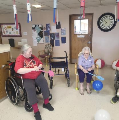 Ann Connel (left) and Nadene Andersen playing fly swatter balloon volleyball.