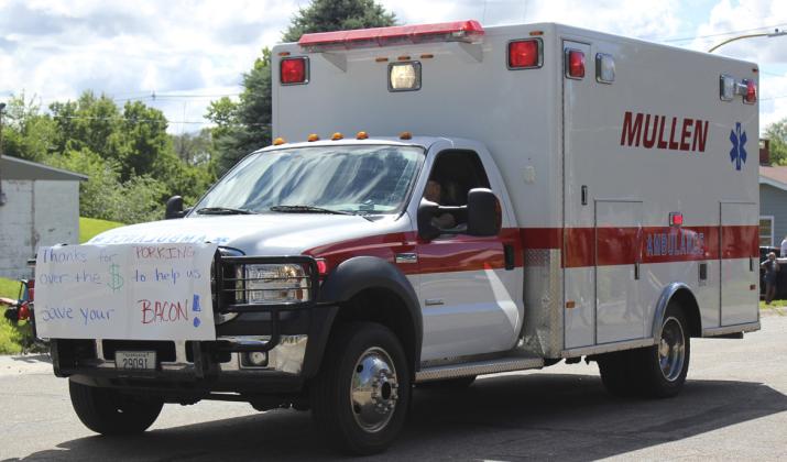 As is tradition, the Mullen ambulances and fire trucks brought up the rear of the parade. From the front of the first ambulance to the back of the second ambulance, signs read: Coming soon new ambulance. Thanks for porking over the $ to help us save your bacon! Wee wee wee thank you!