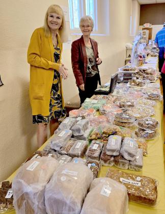 Nancy Isom (left) and her sister Shari McMullen behind the bazaar table making sales. Terri Licking