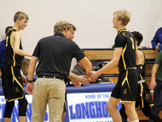 Alex Moore, Head Coach Brad Wright and Samuel Coble give high fives to Clayton Moore and Trevor Kuncl as they come off the court last Thursday at Hyannis. Shelby Welsh