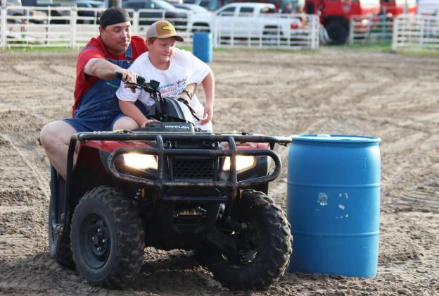 Jason Brown picks up his son Lane from on top of the barrel in the hangman race to head for home. Travis Wolfenden competing in the barrels.